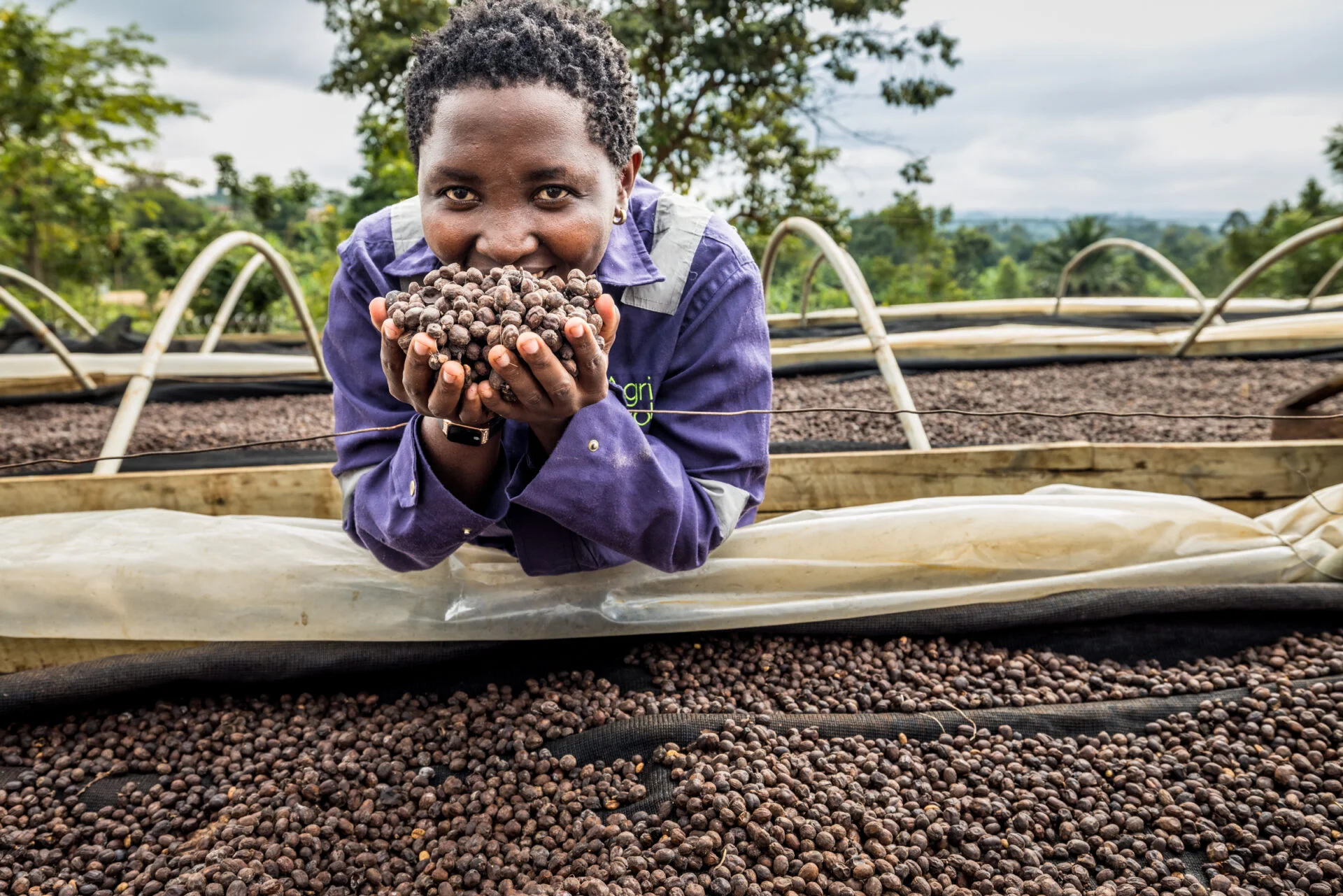 Agri Evolve - Production supervisor Ireen Kabugho posing with the drying coffee. Agri Evolve has many women in management positions.